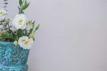 Whilte lisianthus in turquoise vase with copy space