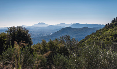 Fototapeta premium View over mountains in hazy sunlight. Corfu, Greece.
