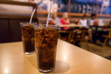 Cola on wood with restaurant background