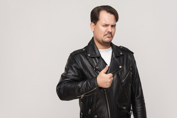 Brutal guy in black jacket wink, thumbs up and looking at camera.