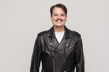 Happiness adult man in leather jacket, looking at camera and toothy smile.