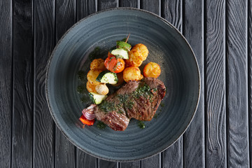 Juicy grilled beef fillet with potato, mushroom, zucchini, tomato, pepper and red onion on wooden skewer
