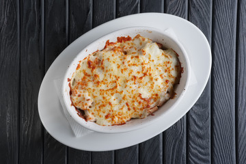 Lasagna Italian cuisine. Top view. Plate on a wooden background.