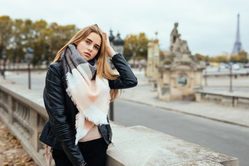 Portrait of a happy young woman smiling in front of Eiffel Tower