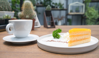 Morning coffee, Cappuccino coffee on wooden table and bakery orange cake background in coffee shop.