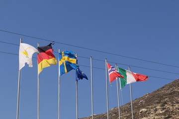 Partly torn, fluttering national flags (respectively Cyprus, Germany, Sweden, European Union, Norway, Italy) in Falassarna Beach in western part of Crete Island, Greece.