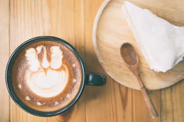 Morning coffee, Cappuccino coffee on wooden table and bakery background in coffee shop , vintage style