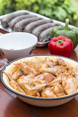 Doprawione surowe mięso kurczaka  w misce stoi na stole.