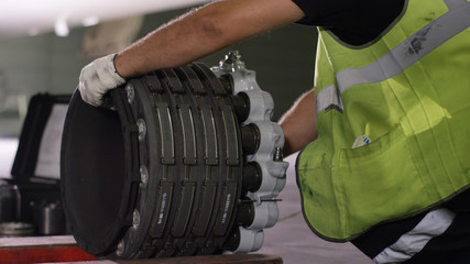 Calm workers controlling aircraft machine and chassis. Aircraft maintenance mechanic inspects plane...
