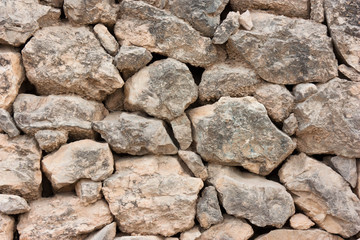 Close-up of a wall of rough cobblestones in a row