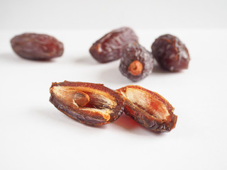 Half dates fruit on white background.
