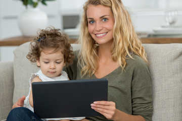mother and daughter watching tv on tablet