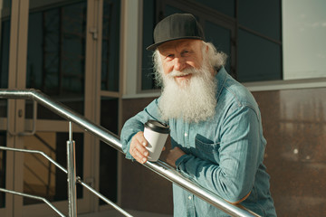 old man with beard and coffee in hand