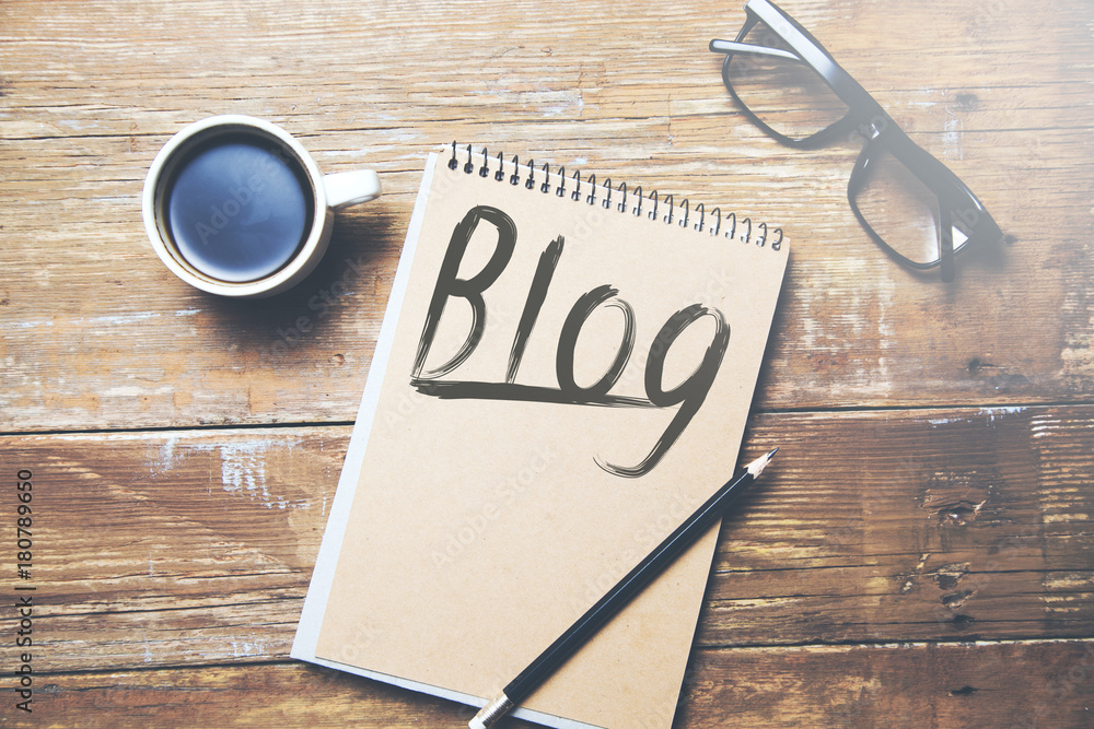 Aufkleber blog text on notepad with cup of coffee on table