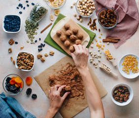 Female hands making candies from dried fruits