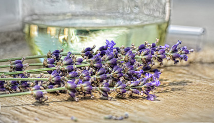 Lavender bunch in front of distilled jar of oil