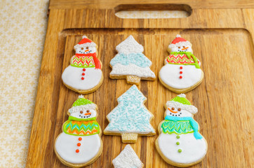 Christmas snowman and tree cookies on the cutting board winter selebration background.