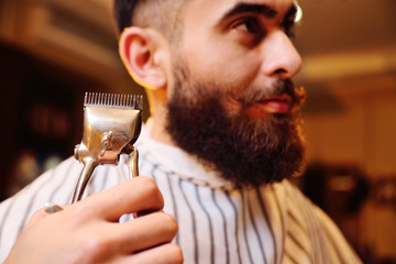 Client during beard shaving in barber shop