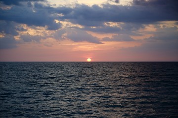 Fototapeta premium Circular Sun Sets over Wave Ocean