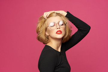 blonde in glasses with eyes closed on a red background