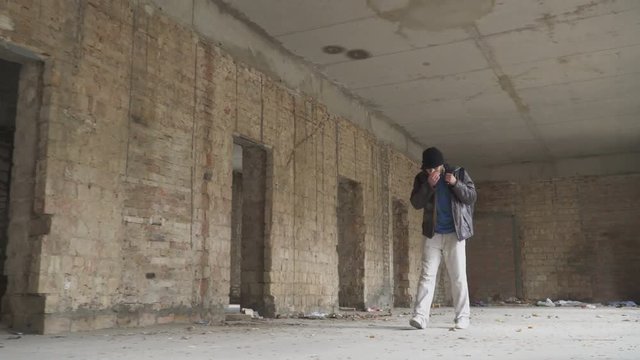 Sick homeless searches something in abandoned building
