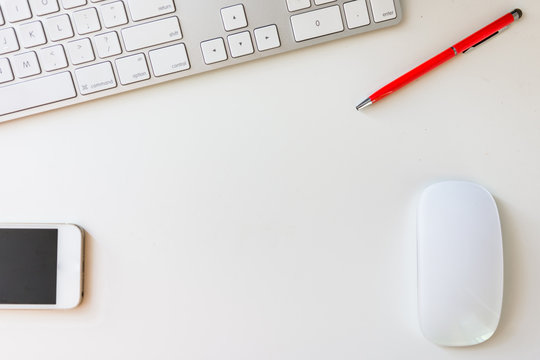 Overhead Of Clean Office Work Space With Keyboard, Smartphone, Mouse And Red Pen