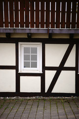 Fachwerkhaus mit Holzgeländer / Die Balkenkonstruktion und das Holzgerüst eines Fachwerkhauses mit einem Holzgeländer.