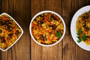 pilaf in a plate on wooden background, top view