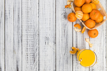 Wooden table with fresh made Tangerine Juice (close-up shot)