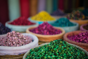 Piles of colourful, vibrant herbs and potpourri in a market stall in a souk in Marrakech, Morocco