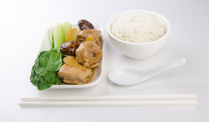 Chicken with rice and vegetables in background