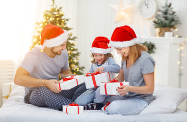 Fototapeta premium happy familymother father and child on Christmas morning in bed