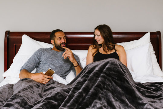 Black And White Couple In Bed Talking