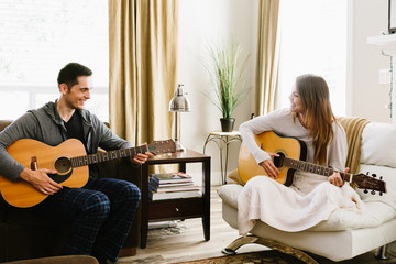 Couple playing guitar together