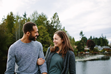 Black and white couple cuddling at the lake