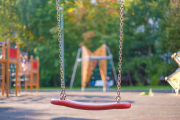 Modern equipped kids playground in sunny day. Chain swings
