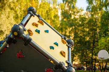 Modern equipped kids playground in sunny day. Wall climbing construction