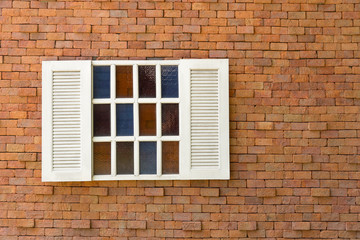 Old red brick wall with white window.