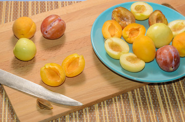 Summer fruits: apples, pears, apricots, plums on a blue plate
