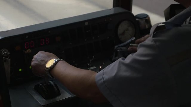 Conductor drives train in Hong Kong, close up