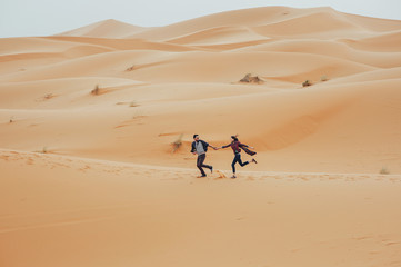 Fototapeta na wymiar Loving couple in the Sahara Desert. Morocco.