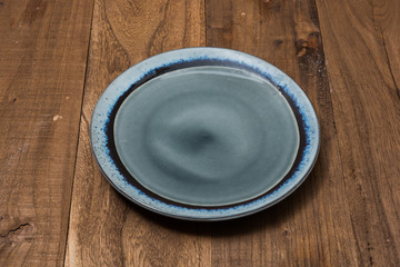 Plate on brown wooden background side view