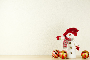 Snowman on bright wall background as a symbol of Christmas and New Year holidays