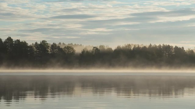 Mog creeping along the surface of the lake at sunrise timelapse, Finland.