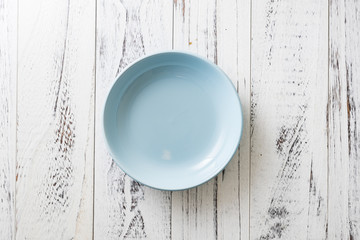 Blue Plate on white wooden background