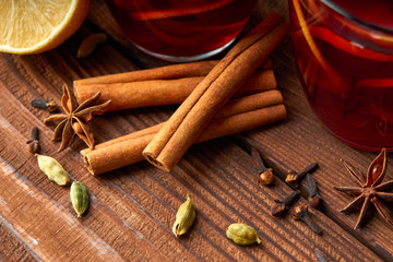 Autumn warming drink. Hot mulled wine, with lemon, anise, cinnamon, cloves, cardamom. Autumn dark still life. Mulled wine with slice of lemon and spices.