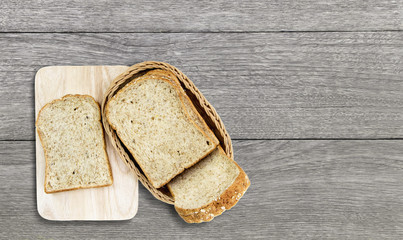 Bread into a basket made of rattan pace on wood table.