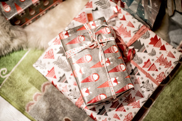 christmas gifts on a rug near christmas tree
