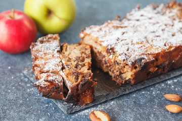 Fruitcake with apple and nuts on the slate
