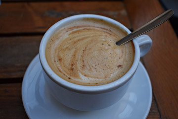 White cup of coffee at restaurant/ top view